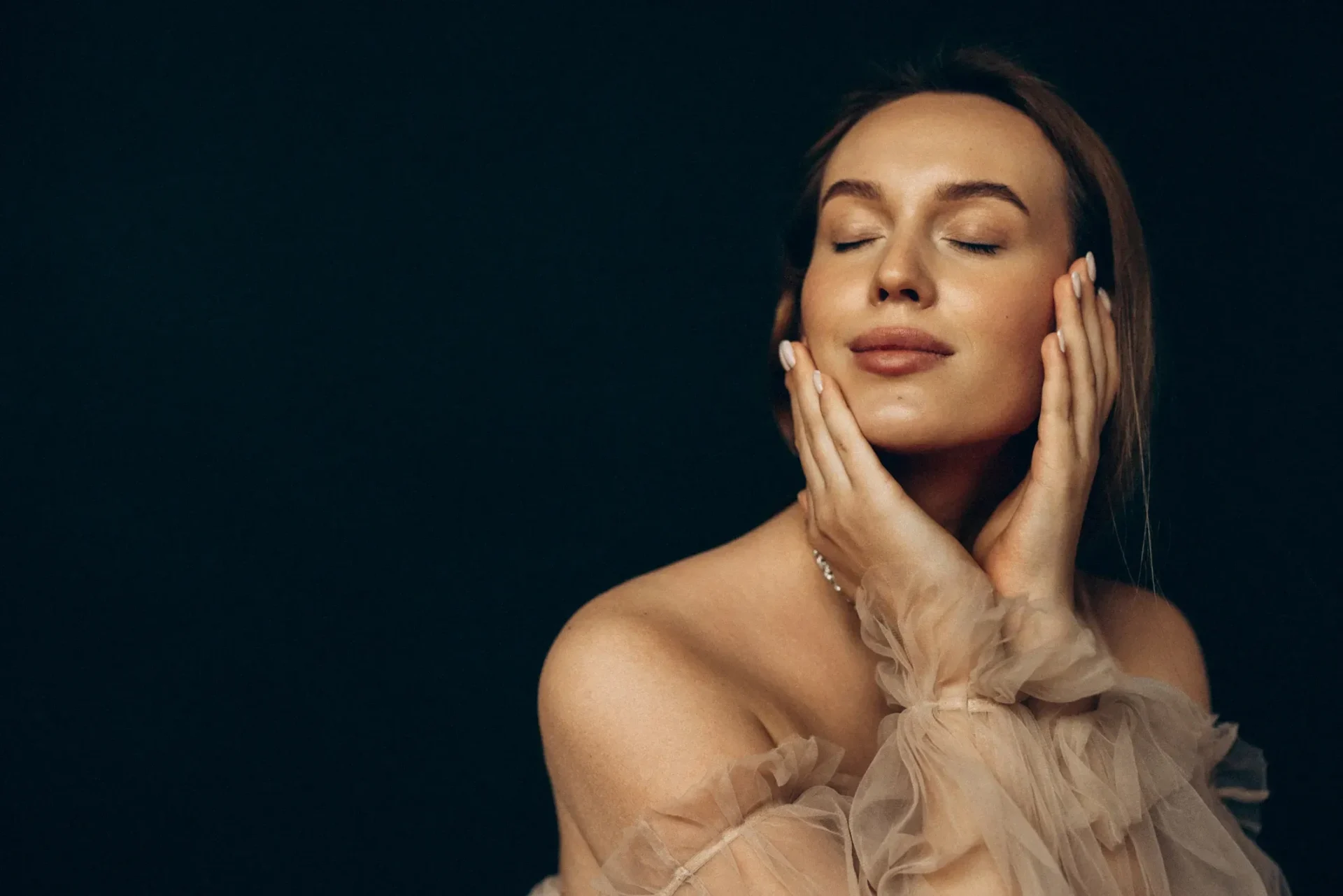 Woman with eyes closed and hands on face.
